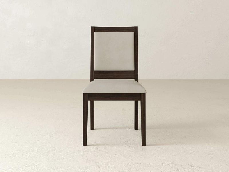 A wooden chair with a cream-colored cushioned seat and backrest is placed against a plain, light-colored background. The chair has a simple, modern design with straight lines and a dark brown frame.