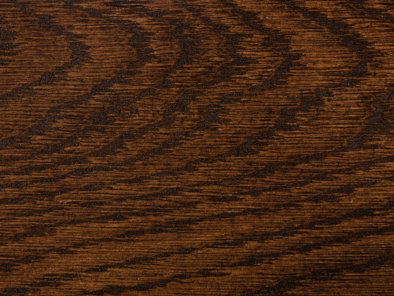 A close-up of the Tobacco on White Oak Sample from James+James showcases its rich brown color with distinctive horizontal grain patterns. The surface texture appears smooth, enhanced by natural variations in the wood that add depth and character.