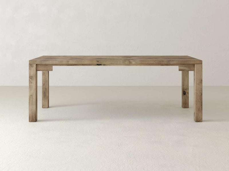 The Jonathan Desk by James+James is a farmhouse-style piece featuring a rectangular top and straight legs. Made of solid hardwood, it has a natural wood finish that highlights its grain and texture, set against a plain white background.