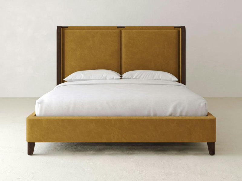 The Holden Bed – Velvet by James & James boasts a luxurious mustard-colored velvet headboard and frame, complete with two white pillows and duvet. Set against a plain, light wall and light floor, it epitomizes contemporary design.