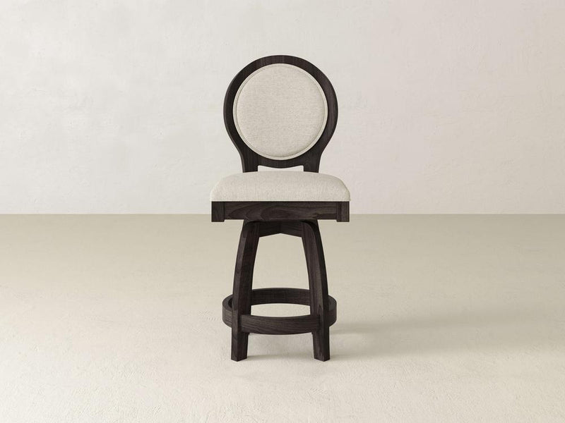 The Alice Swivel Stool by James & James boasts a dark-finished maple frame, beige padded seat, and circular backrest. Its round base suits a light floor against a white wall perfectly.