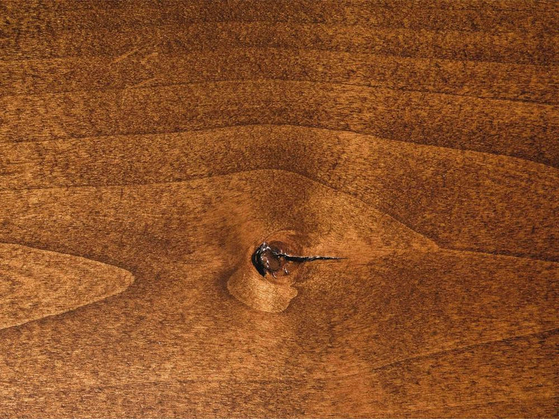 A close-up of the Tuscany on Alder Sample by James+James showcases a prominent knot at its center. The wood grain exhibits warm, rich brown tones, with visible natural patterns and textures that contribute to its rustic, organic feel.