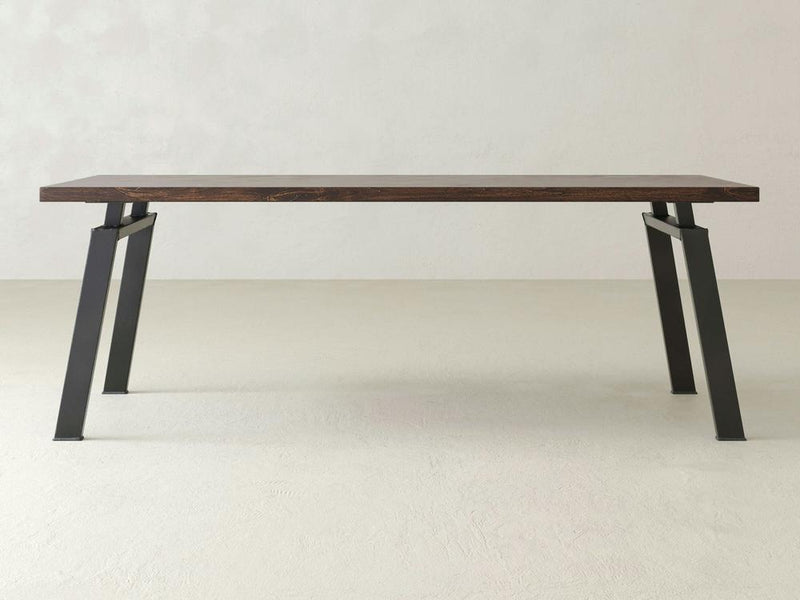 The Fulton Desk - Tobacco by James+James is a minimalist, modern desk featuring a rectangular wooden top with a dark wood finish and angled metal legs in a gray color. The desk boasts an open design with a simple, sturdy frame, perfect for any contemporary space.