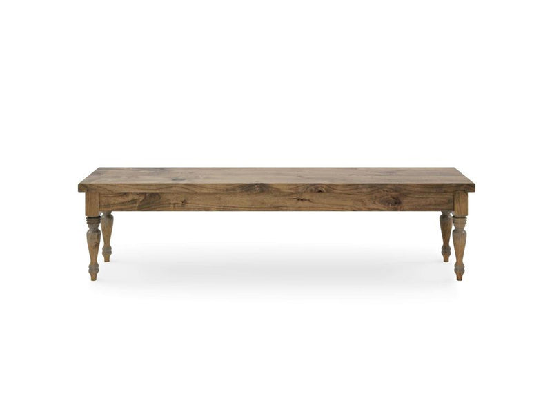 The Chateau Bench by James & James is a simplistic, rectangular wooden piece with a natural finish and four decorative turned legs styled in Harvest Wheat. It stands against a white backdrop.