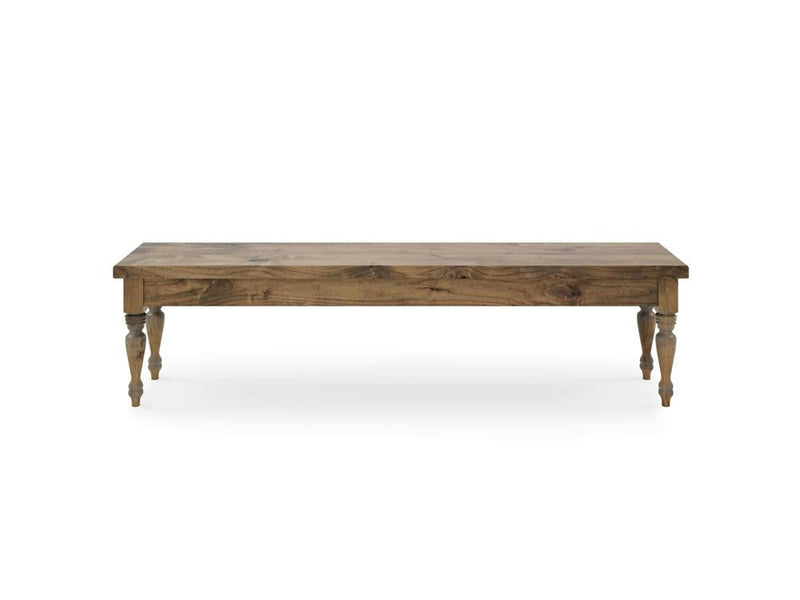 The Chateau Bench by James & James is a simplistic, rectangular wooden piece with a natural finish and four decorative turned legs styled in Harvest Wheat. It stands against a white backdrop.