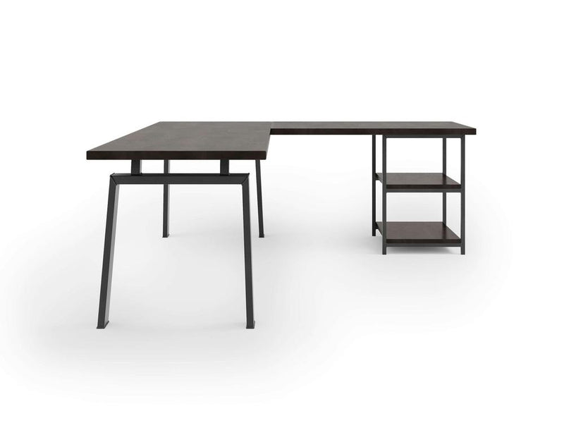 The Fulton Corner Desk by James & James features a modern L-shaped design with a charred ember top and black metal legs. One side serves as a standard desk, while the other extends perpendicularly with two open shelves for extra storage against a plain white background.